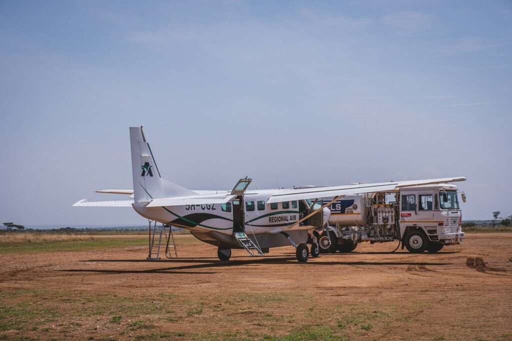 a small plane parked on a dirt field